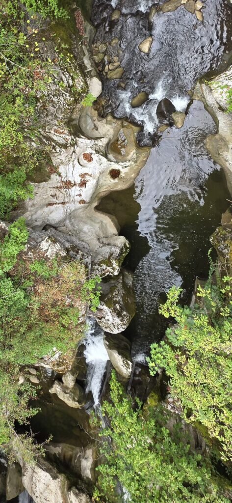 Smooth limestone scooped into pools and channels by the Sierroz river, with white water spilling between them