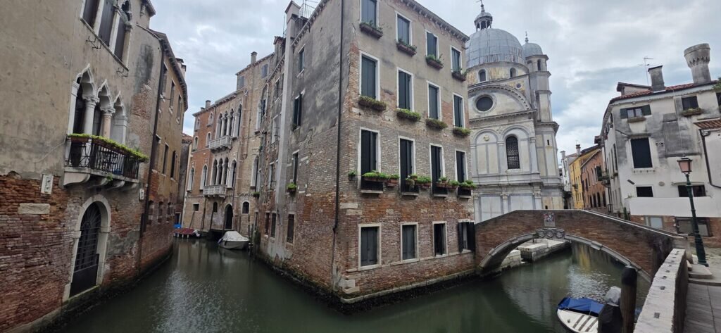Santa Maria dei Miracoli in Venice, a small marble-clad Renaissance church beside a quiet canal with a stone footbridge