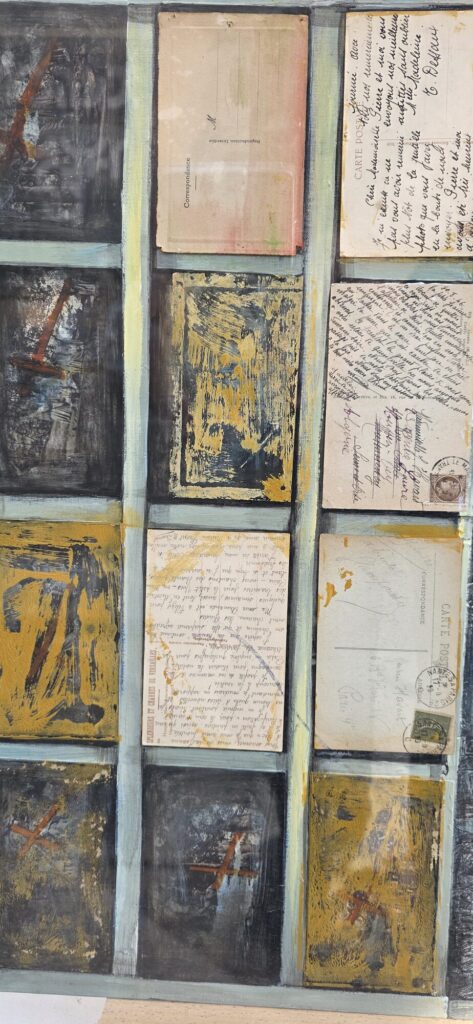 Mixed media artwork on an easel in a Popincourt gallery window, made of layered vintage postcards with stamps and handwriting forming the composition, label reading Susana Machado